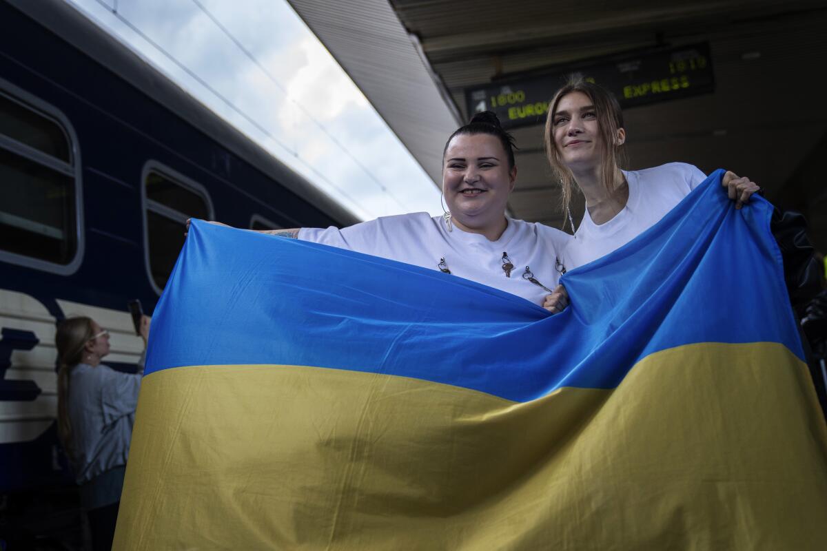 La rapera ucraniana alyona alyona, izquierda, y la cantante Jerry Heil posan para medios con la bandera ucraniana