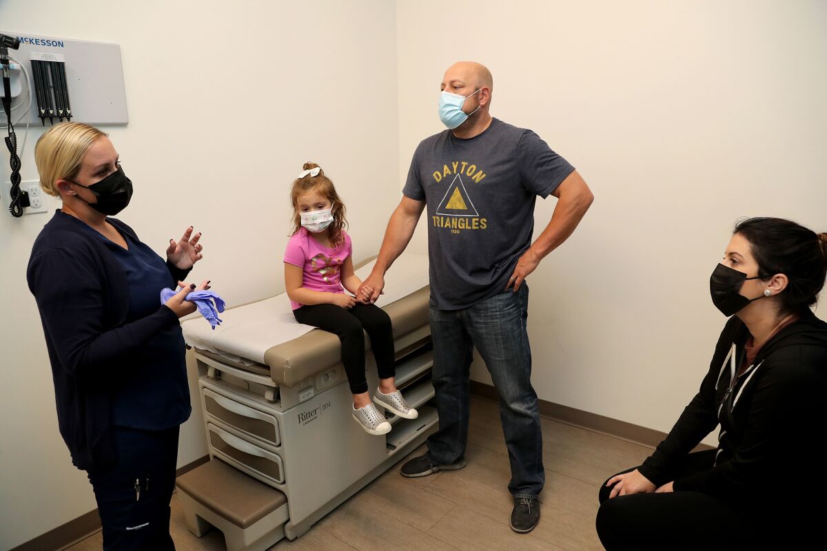 Amanda Maxwell, left, the clinical nurse manager, speaks to parents Marni and Marc, at a COVID-19 vaccine appointment.