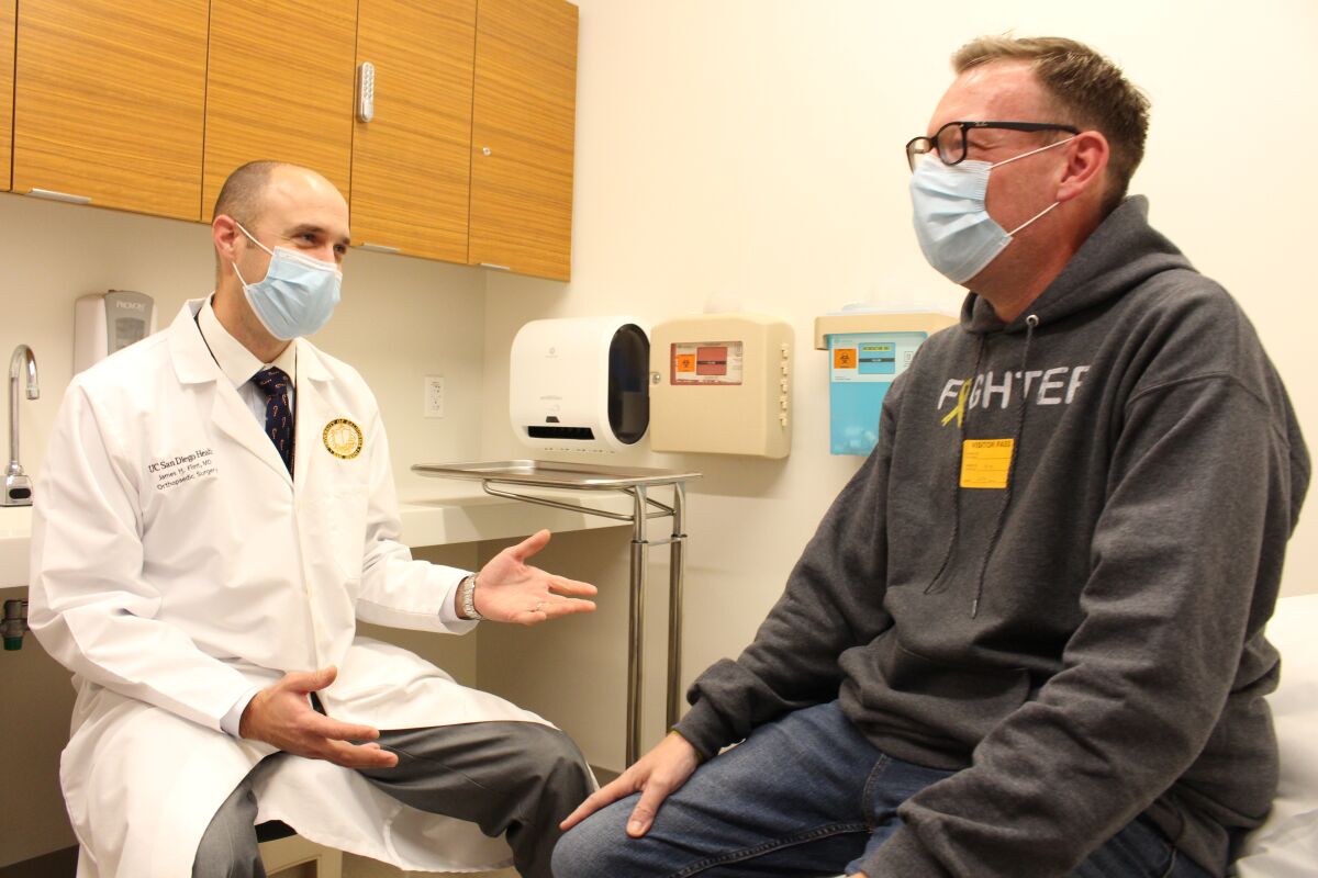 UCSD Health orthopedic surgeon Dr. James Flint and his patient Colin Jackson talk during a recent office visit.