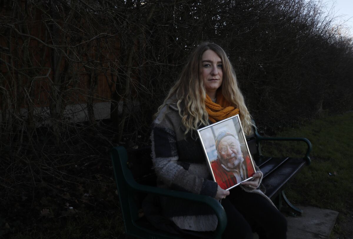 FILE - In this Friday, Jan. 22, 2021 file photo, Jo Goodman, co-founder of the COVID-19 Bereaved Families for Justice group, holds a portrait of her late father Stuart as she poses for a photo in London. Jo's father Stuart died of COVID-19, in April 2020. British Prime Minister Boris Johnson has on Wednesday, May 12 confirmed that an independent public inquiry into the government’s handling of the coronavirus pandemic will start hearing evidence next year. While welcoming the announcement, a leading group representing the bereaved think it should begin sooner. (AP Photo/Alastair Grant)