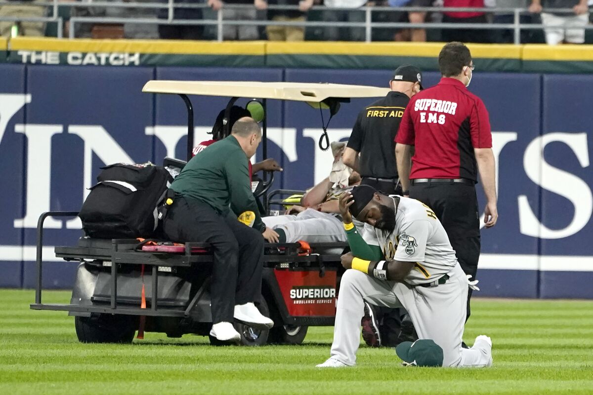 Oakland Athletics' Josh Harrison reacts as starting pitcher Chris Bassitt is taken off the field after Bassitt was hit in the head by a ball hit by Chicago White Sox's Brian Goodwin during the second inning of a baseball game, Tuesday, Aug. 17, 2021, in Chicago. (AP Photo/Charles Rex Arbogast)