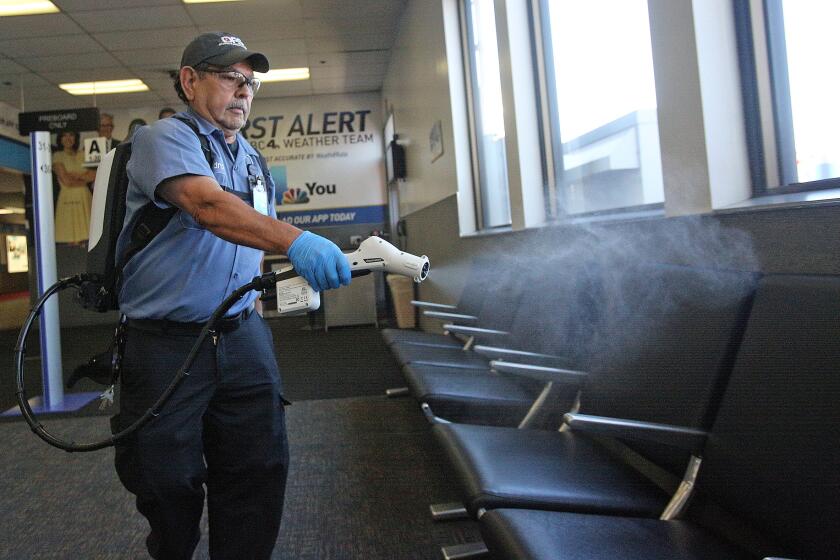 Isidro Vaca, with DFS, Diverse Facility Solutions, sanitizes a gate waiting area with a Protexus Electrostatic Sprayer to sanitize it in Burbank on Friday, April 3, 2020. The airport, along with the Ontario International Airport, are using the electrostatic device to sanitize surfaces deeper and more effectively than previously used cleaning methods. The airport is stepping up its sanitization practices to protect passengers from the spread of coronavirus.