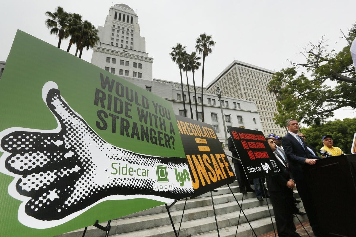 William Rouse, the general manager of Los Angeles Yellow Cab, takes questions from the media as hundreds of Los Angeles area taxi drivers circle City Hall to protest ride-sharing services.