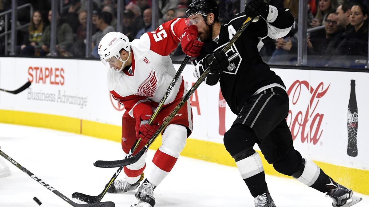 Kings center Jeff Carter, right, takes a shot to the face from Red Wings defenseman Alexey Marchenko.