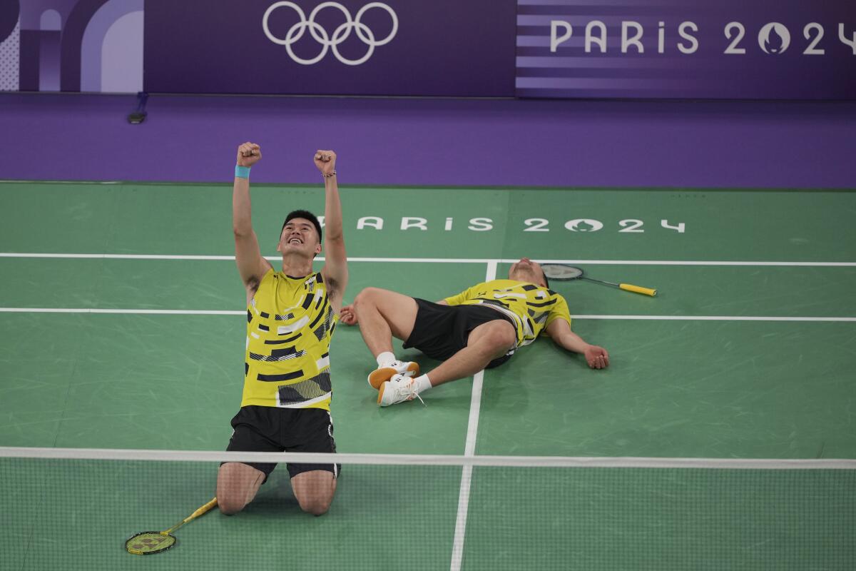 Taiwan's Lee Yang, right, and Wang Chi-Lin celebrate after defeating China in the men's badminton doubles gold medal match.