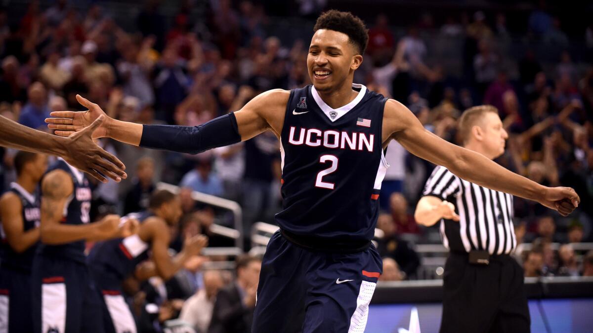 Connecticut's Jalen Adams is congratulated after tying the score against Cincinnati at the end of the third overtime with an 80pfoot shot Friday night.
