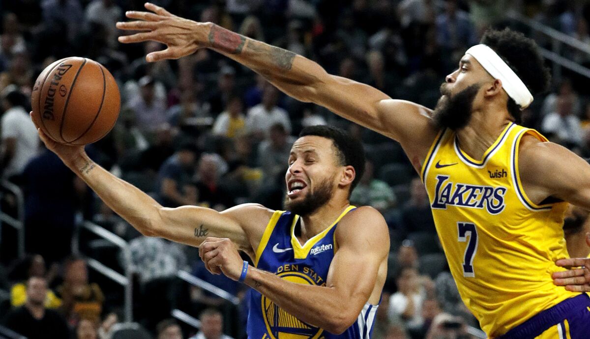 Lakers center JaVale McGee tries to block a layup by Warriors guard Stephen Curry during a preseason game Oct. 10 in Las Vegas.