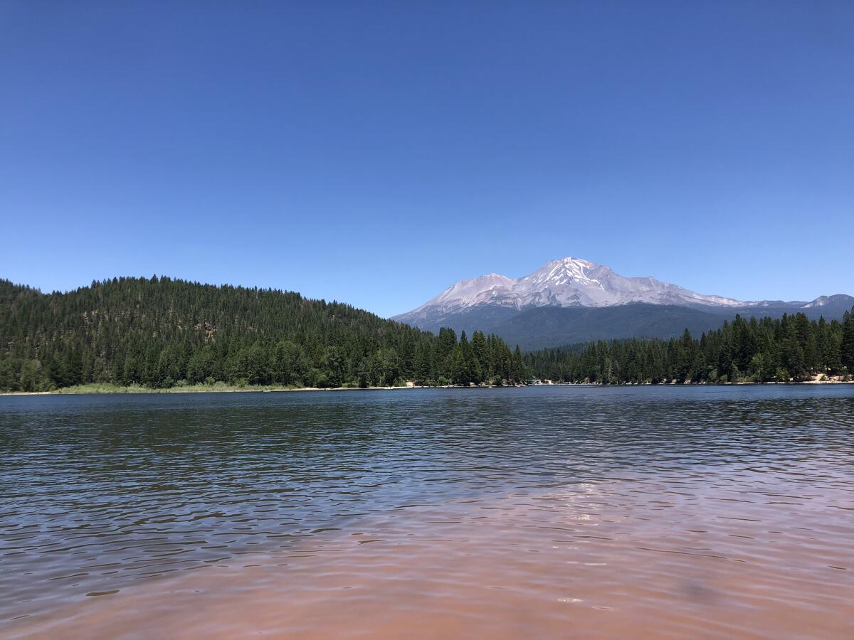 A big lake with hills and mountains in the background.