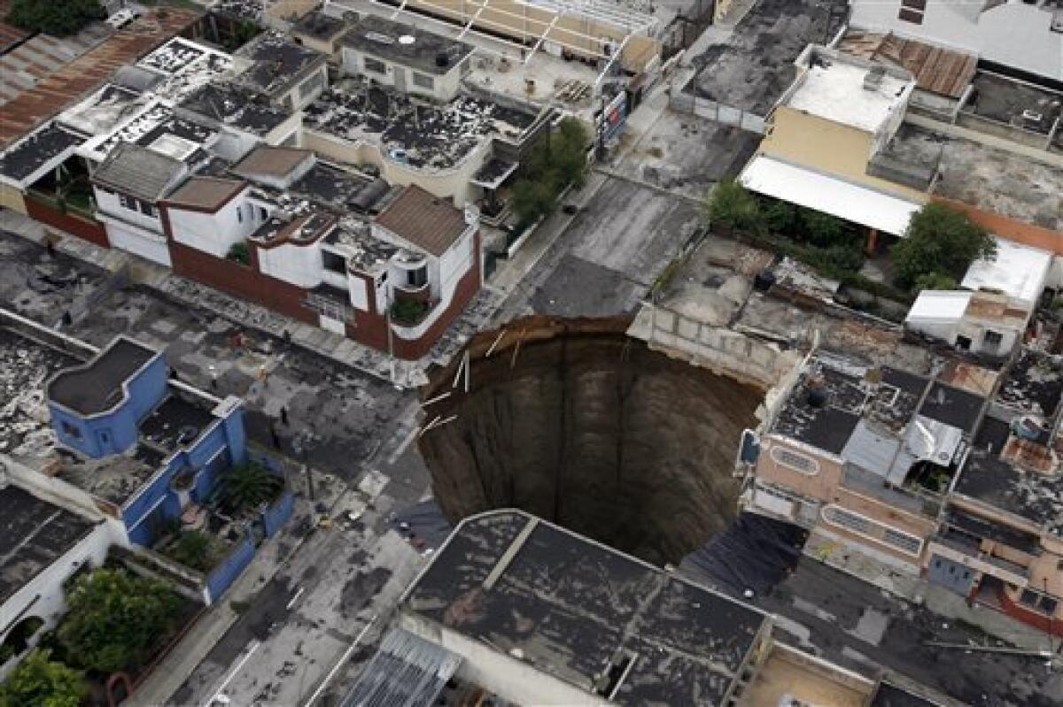 A sinkhole covers a street intersection in downtown Guatemala City, Wednesday, June 2, 2010. Authorities blamed heavy rains caused by tropical storm Agatha as the cause of the crater that swallowed a a three-story building but now say they will be conducting further studies to determine the cause. In April 2007 another giant sinkhole in the same area killed 3 people. (AP Photo/Moises Castillo)