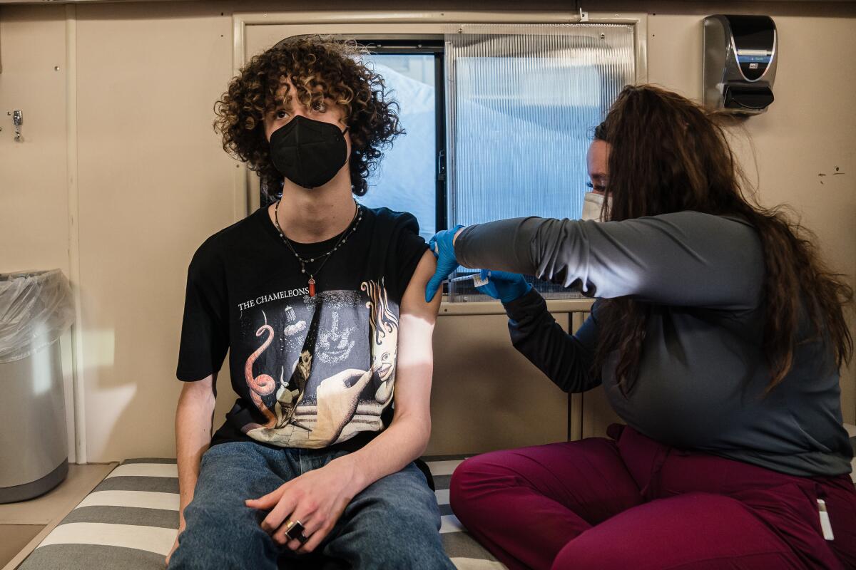 A teenager gets a COVID-19 vaccine booster shot at a UC San Diego Health Mobile Vaccine Clinic in January 2022.