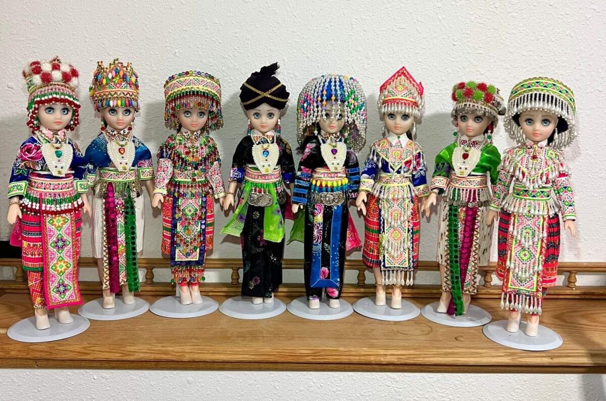 Hmong dolls displayed on a shelf.