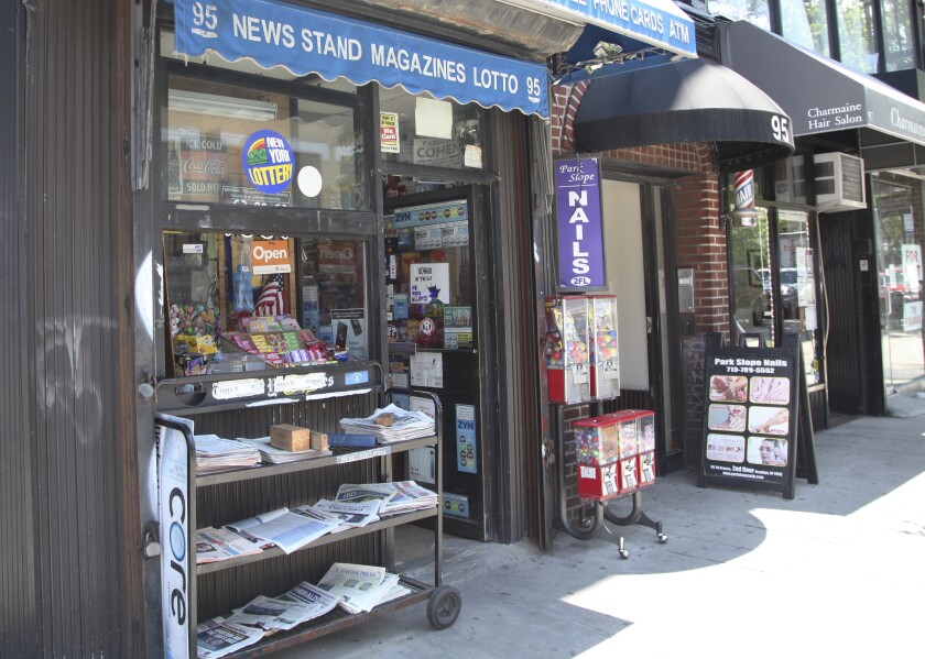 Various local newspapers appear outside a convenience store in the Brooklyn borough of New York on June 30, 2022. The United States continues to see newspapers die at the rate of two per week, according to a report issued Wednesday on the state of local news. The country had 6,377 newspapers at the end of May, down from 8,891 in 2005, the report said. (AP Photo/Mark Kennedy)