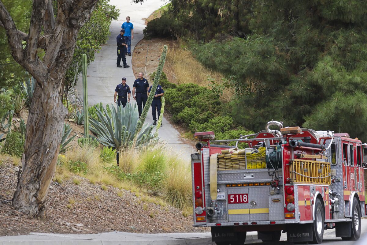 An L.A. County fire protection crew surveys a residential area in Duarte on Tuesday amid a threat from the Bobcat fire.