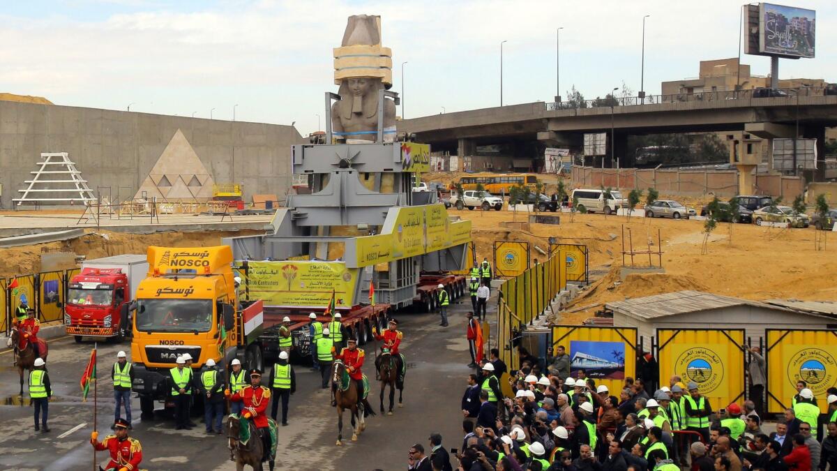 Egyptians celebrate as the giant granite statue of the ancient Pharaoh Ramses II is loaded onto a truck and transferred to its permanent home at the atrium of the Grand Egyptian Museum near Giza, Egypt.