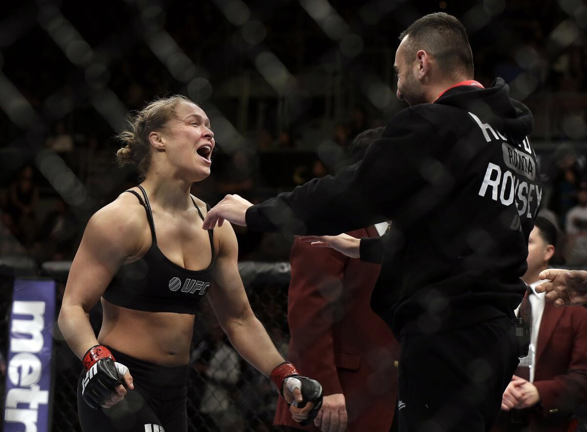Ronda Rousey, left, goes to hug trainer Edmond Tarverdyan after defeating Sara McMann in a UFC women's bantamweight title fight Saturday in Las Vegas.