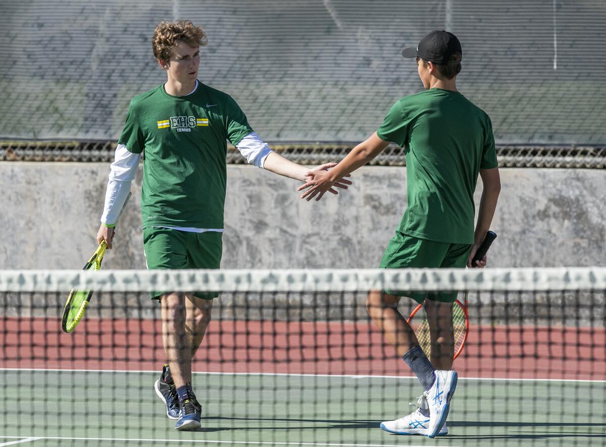 Edison's Trevor Dodge, left, high fives Lloyd Hitch during a doubles match against Huntington Beach on Thursday.