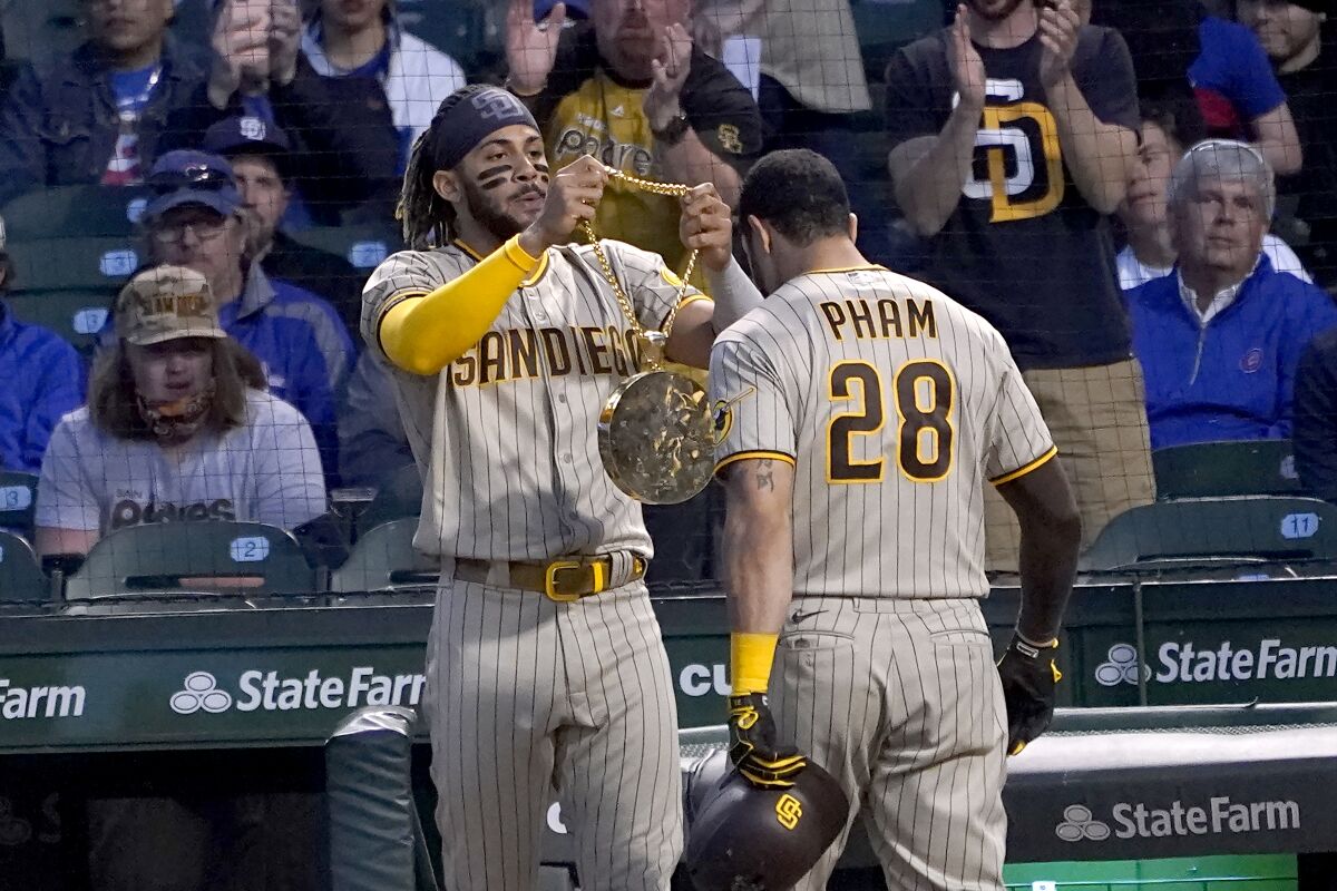 San Diego Padres' Tommy Pham (28) gets the chain swag from Fernando Tatis Jr. after Pham hit a two-run hime run off Chicago Cubs starting pitcher Kyle Hendricks during the fifth inning of a baseball game Tuesday, June 1, 2021, in Chicago. (AP Photo/Charles Rex Arbogast)