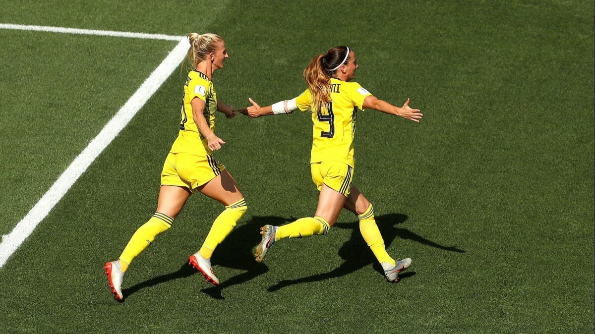 Sweden's Kosovare Asllani, right, celebrates with Sofia Jakobsson after scoring in the 11th minute for the game's first goal in the Swedes' 2-1 win over England on Saturday.