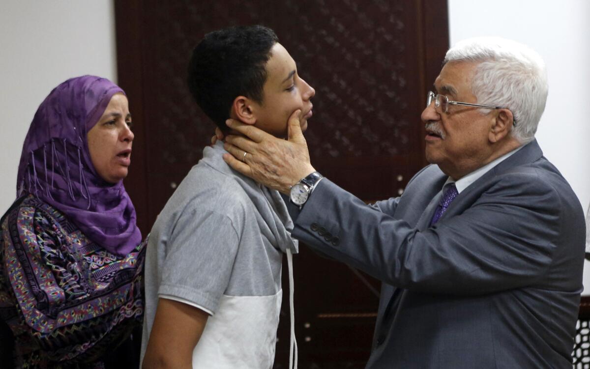 Palestinian Authority President Mahmoud Abbas examines the injuries of Palestinian American teen Tariq Abukhdeir during a meeting on July 7.