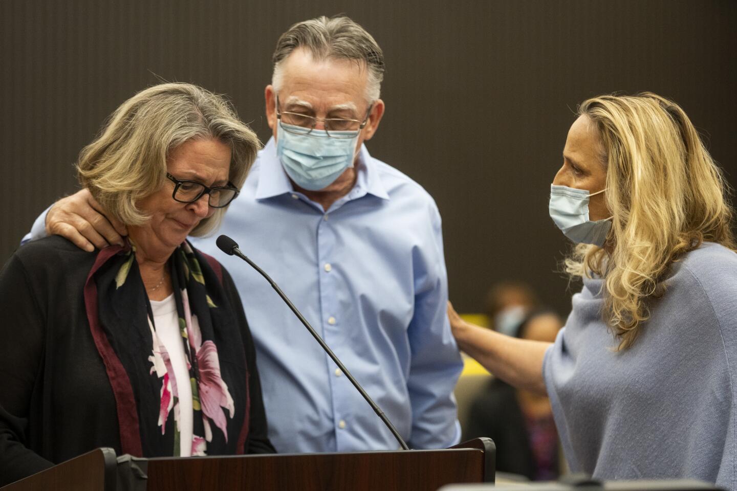 A man and a woman comfort another woman in court.