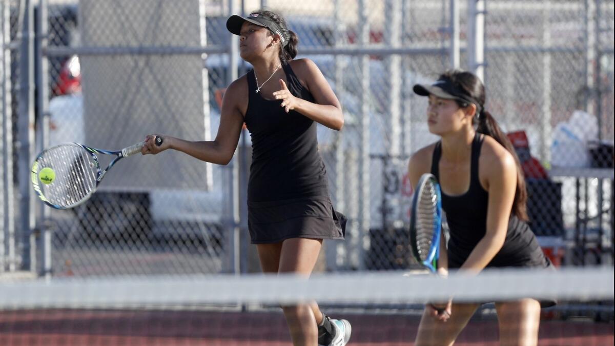 Huntington Beach High doubles players Kaitlyn Palacio, left, and Alissa Wong compete during a No. 1 doubles set against South Pasadena in the quarterfinals of the CIF Southern Section Division 3 playoffs on Monday.