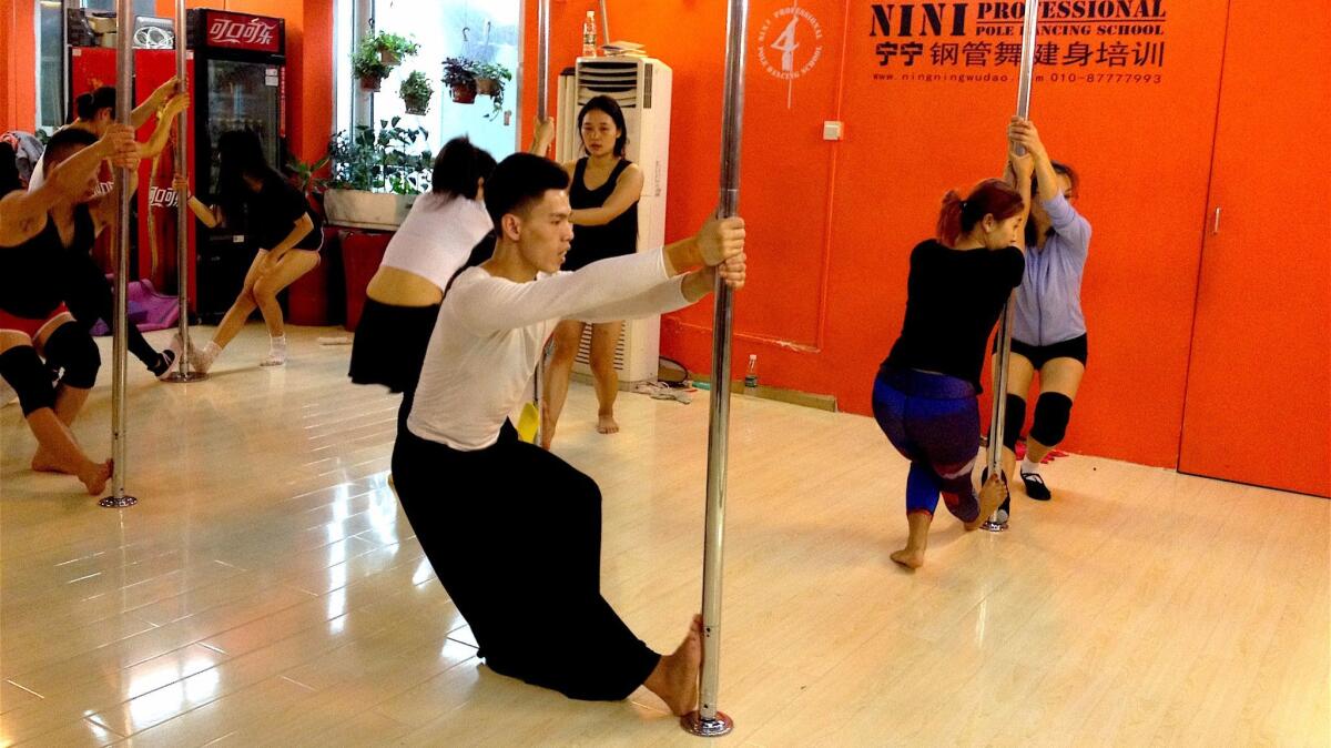 Hou Xing, 23, teaches a basic pole dancing technique course. (Yanan Wang / For The Times)