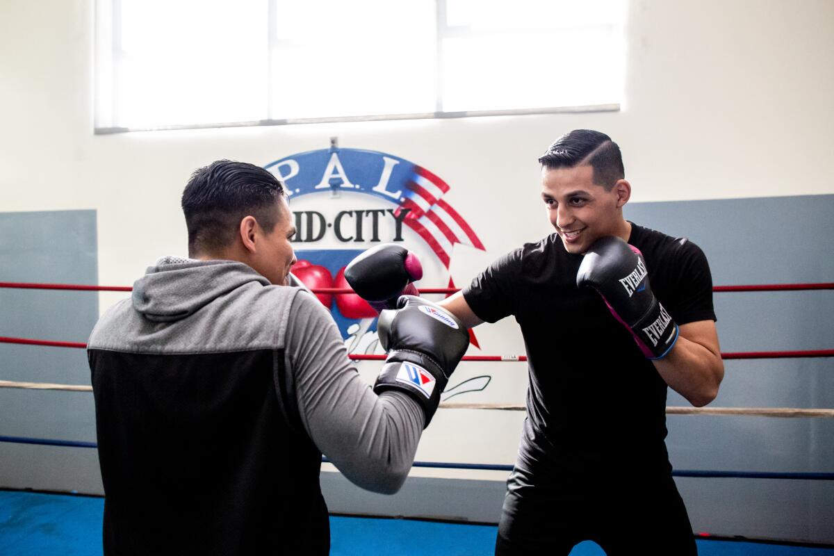 Two men box inside a ring.