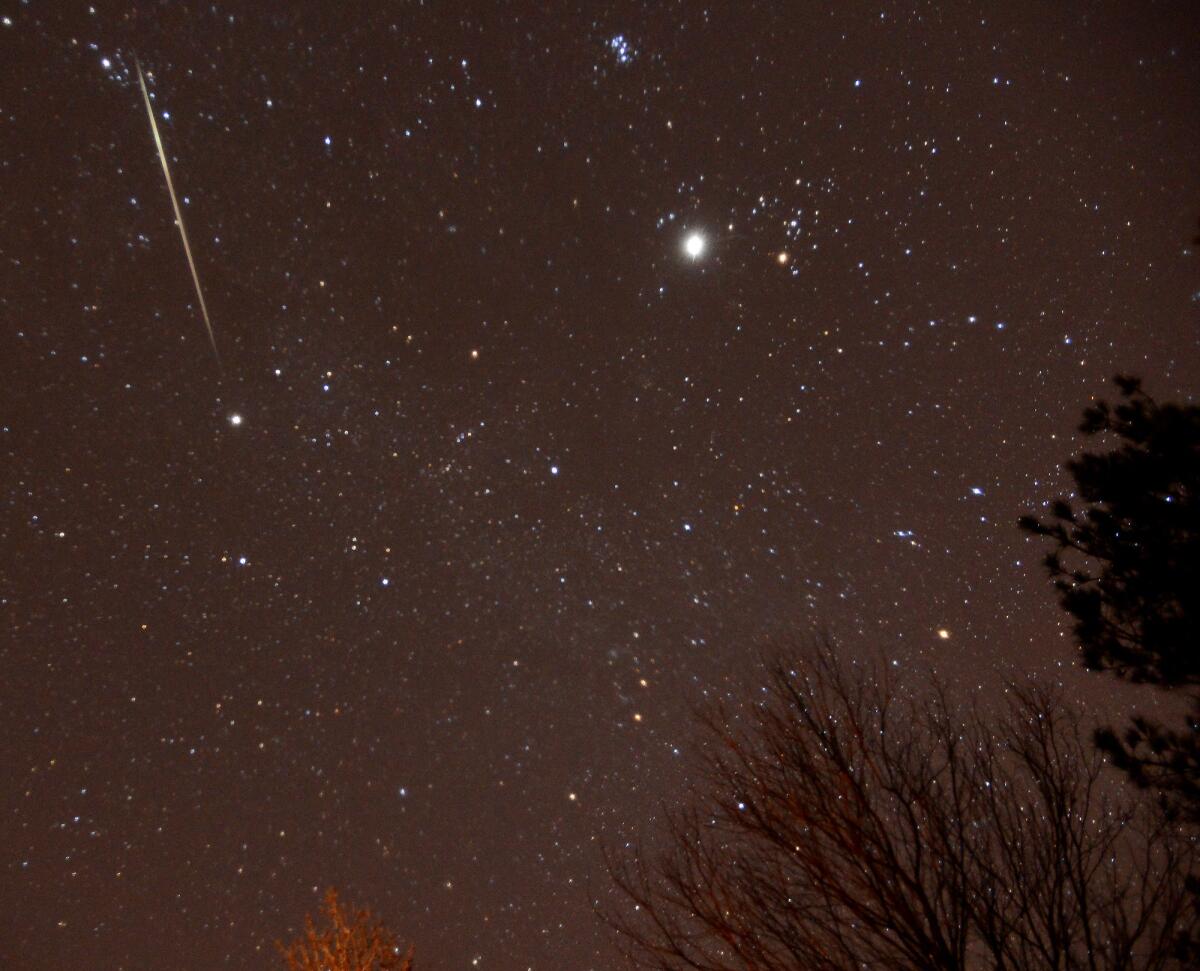 A meteor streaks across the sky over Springville, Ala., during a Geminid meteor shower last year.
