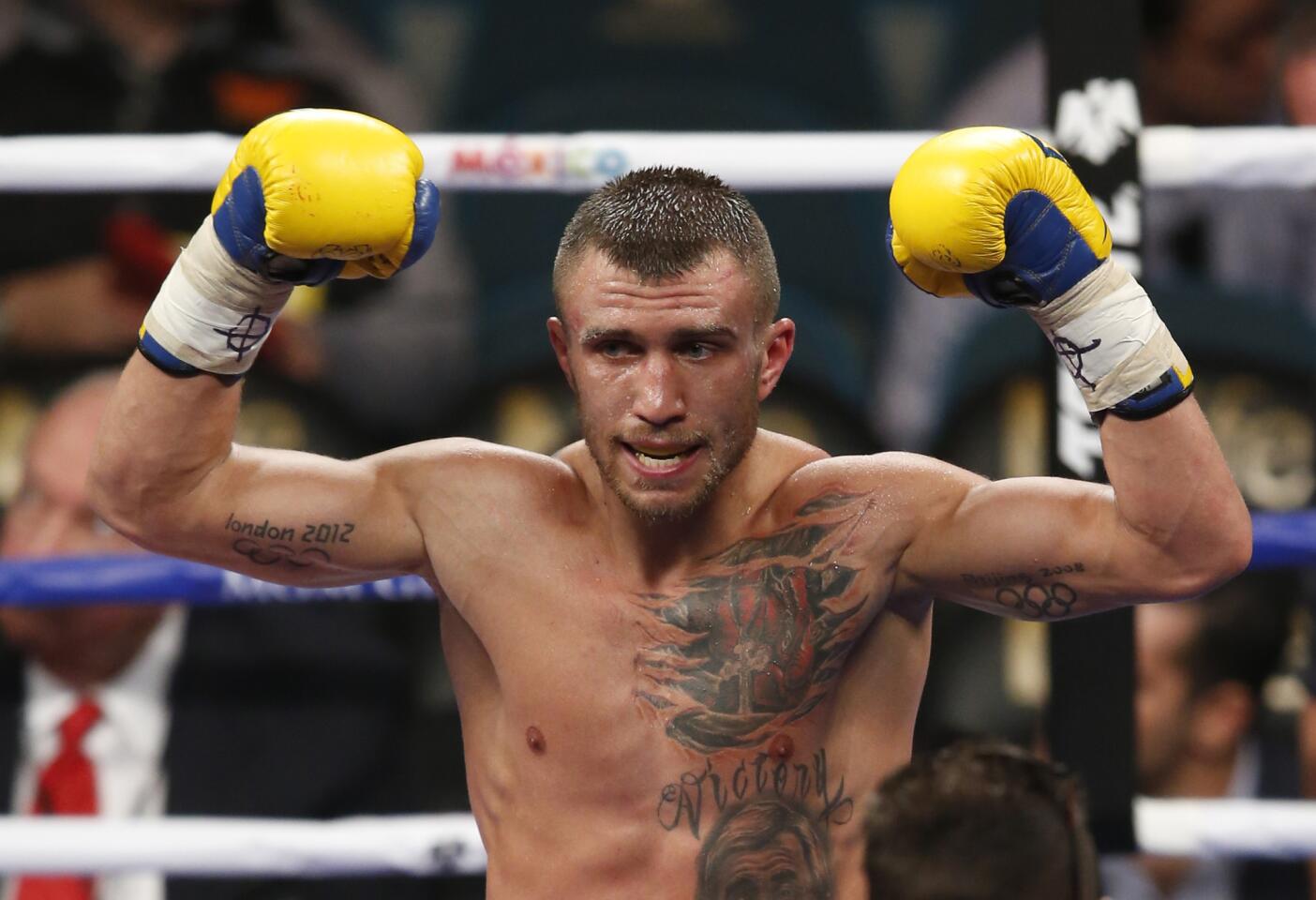 Vasyl Lomachenko celebrates his ninth-round knockout victory over Gamalier Rodriguez in their featherweight title fight at the MGM Grand Garden Arena.