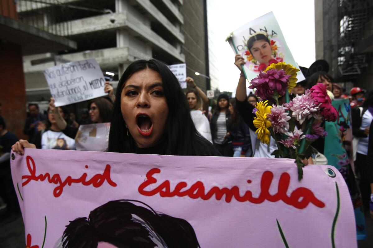 A woman holds a banner with an image of Ingrid Escamilla during a demonstration