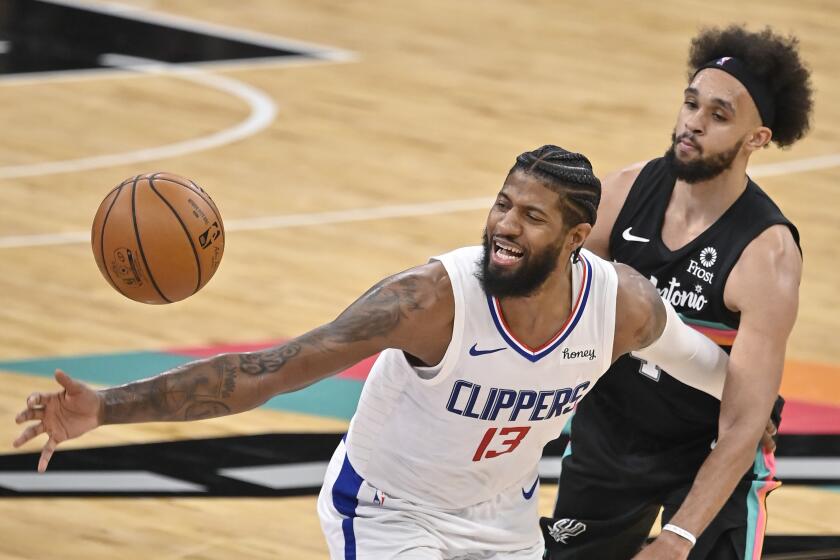 Los Angeles Clippers' Paul George (13) loses the ball as he is fouled by San Antonio Spurs' Derrick White during the second half of an NBA basketball game on Thursday, March 25, 2021, in San Antonio. (AP Photo/Darren Abate)