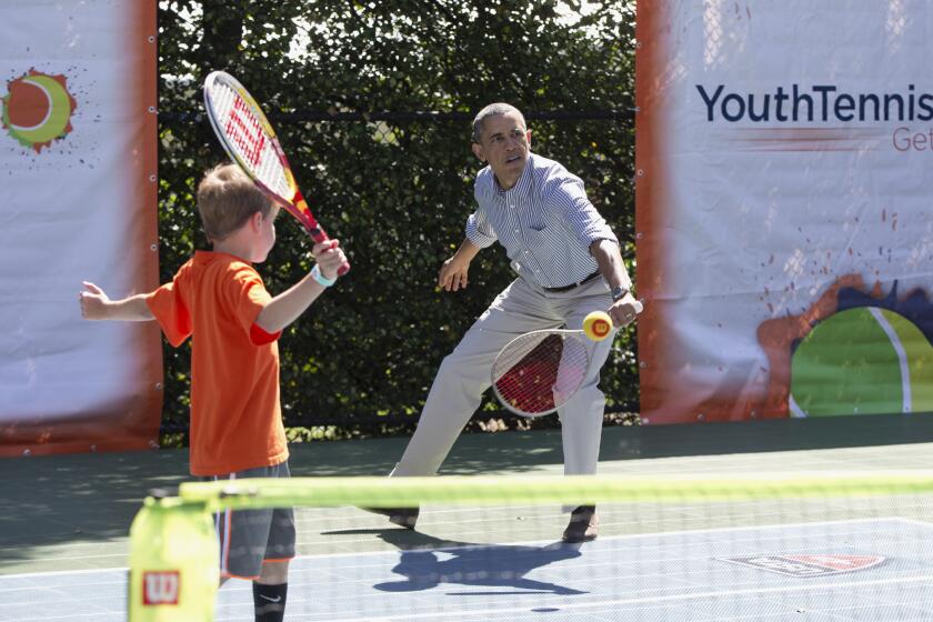 President Obama plays doubles tennis with a young partner during the annual White House Easter Egg Roll.