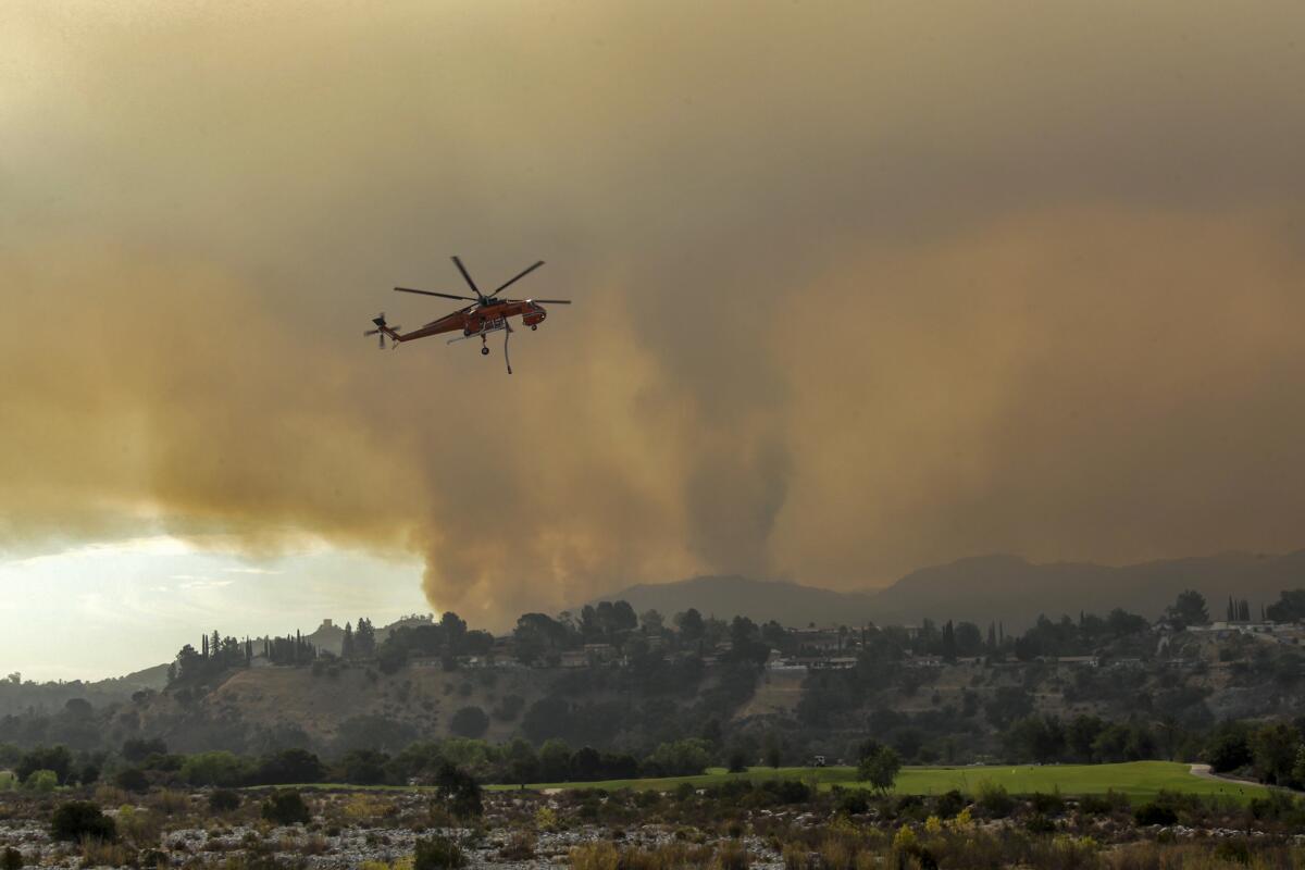 A firefighting helicopter makes its way toward the La Tuna fire in the Verdugo Mountains.