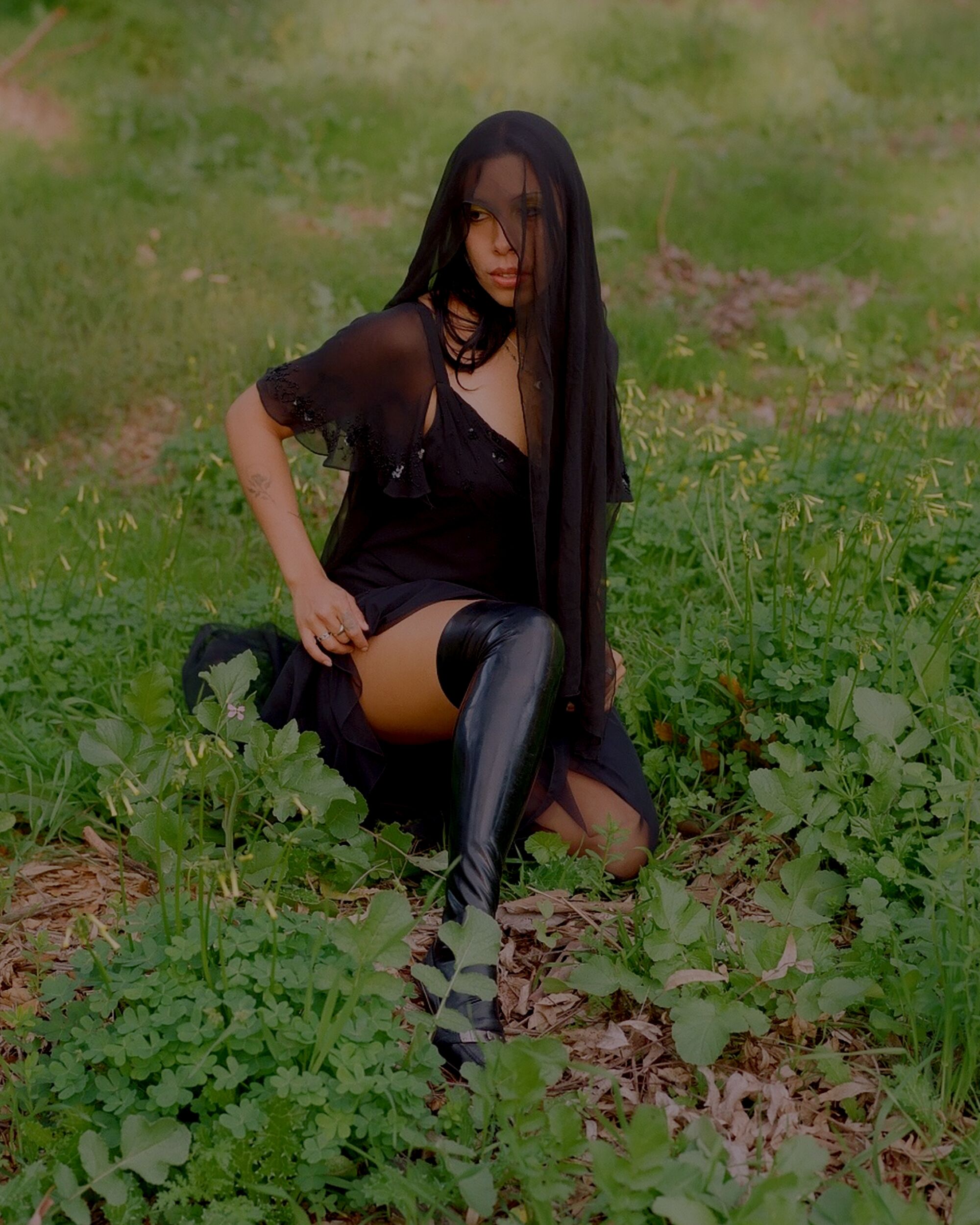 Mia Carucci wears a black veil in the forest.