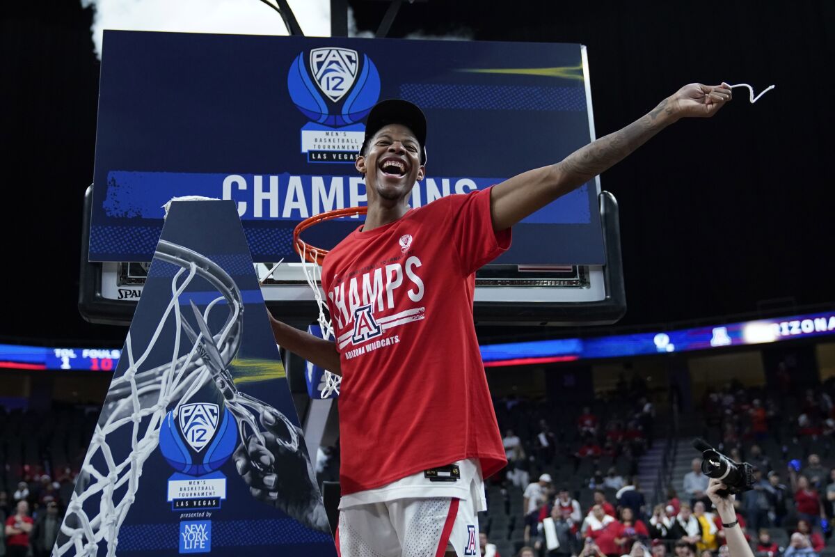 Arizona's Dalen Terry celebrates while cutting a piece of the net.