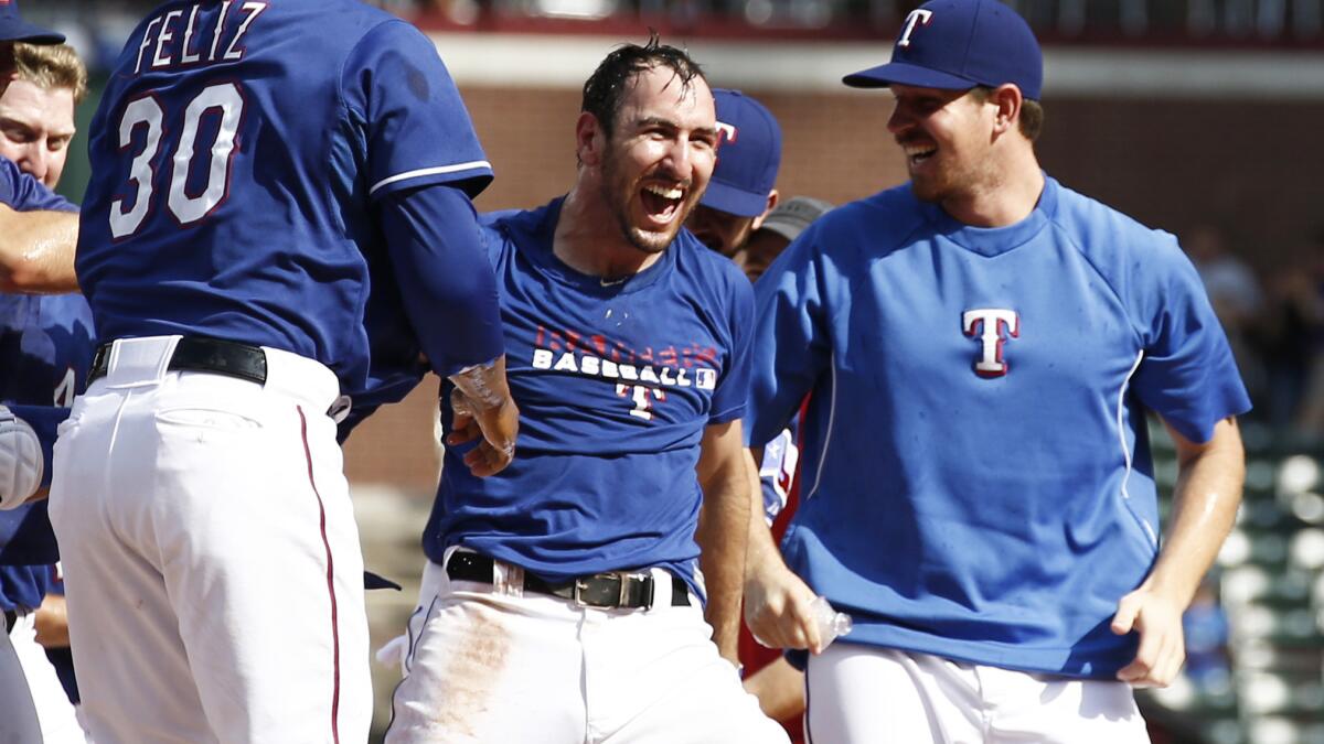 Texas Rangers third baseman Adam Rosales, second right, celebrates with his teammates after driving in the winning run in the ninth inning of the team's 3-2 win over the Angels on Sunday.