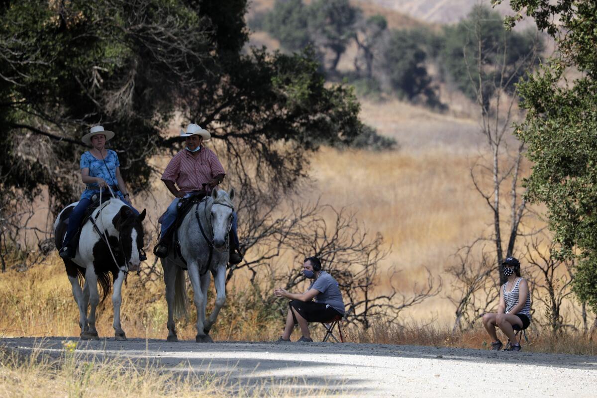 Riders at Paramount Ranch as Kevin Gossett and Francesca Africano, seated, participate in the interactive "Fire Season."
