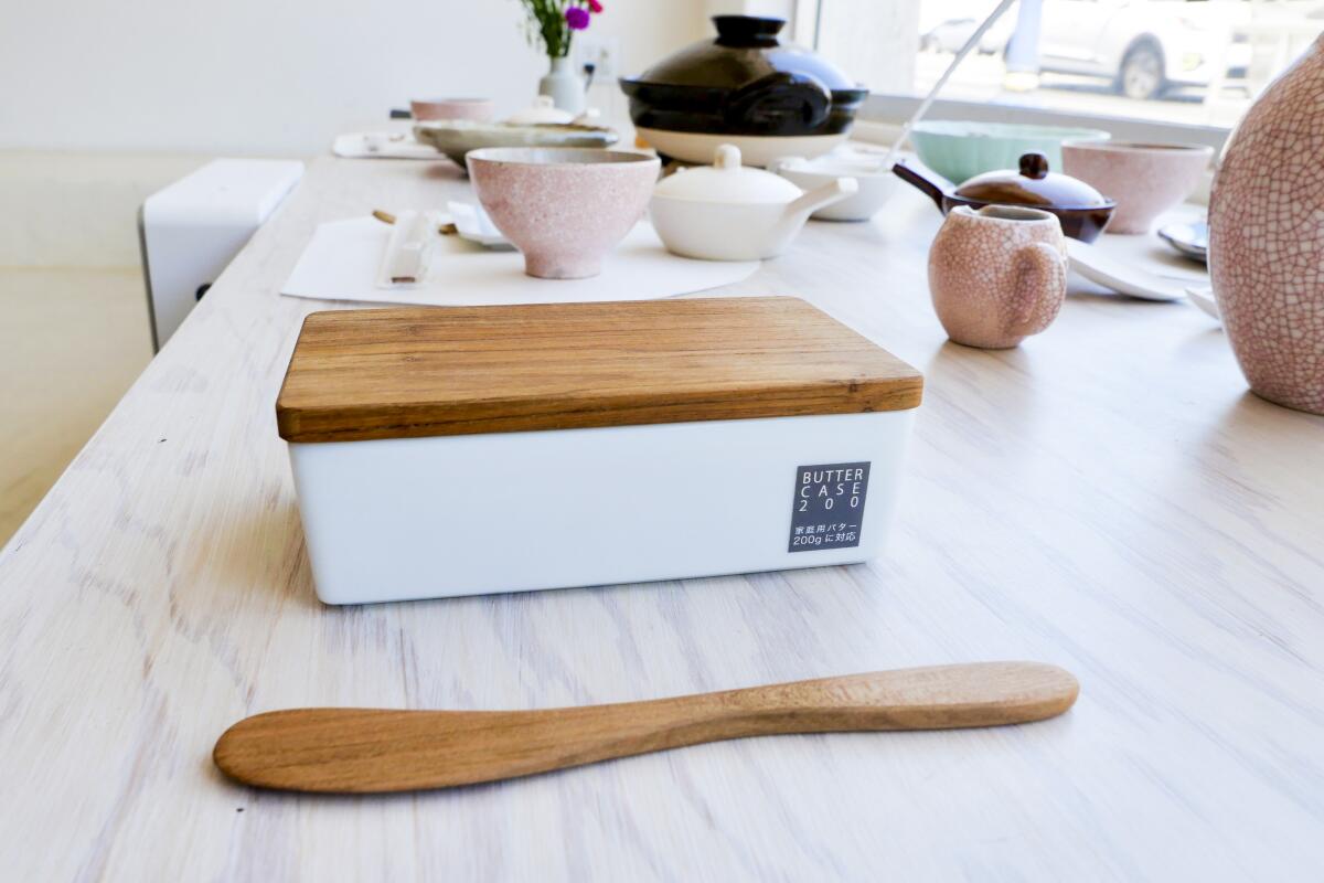 A butter dish and spoon on a marble table