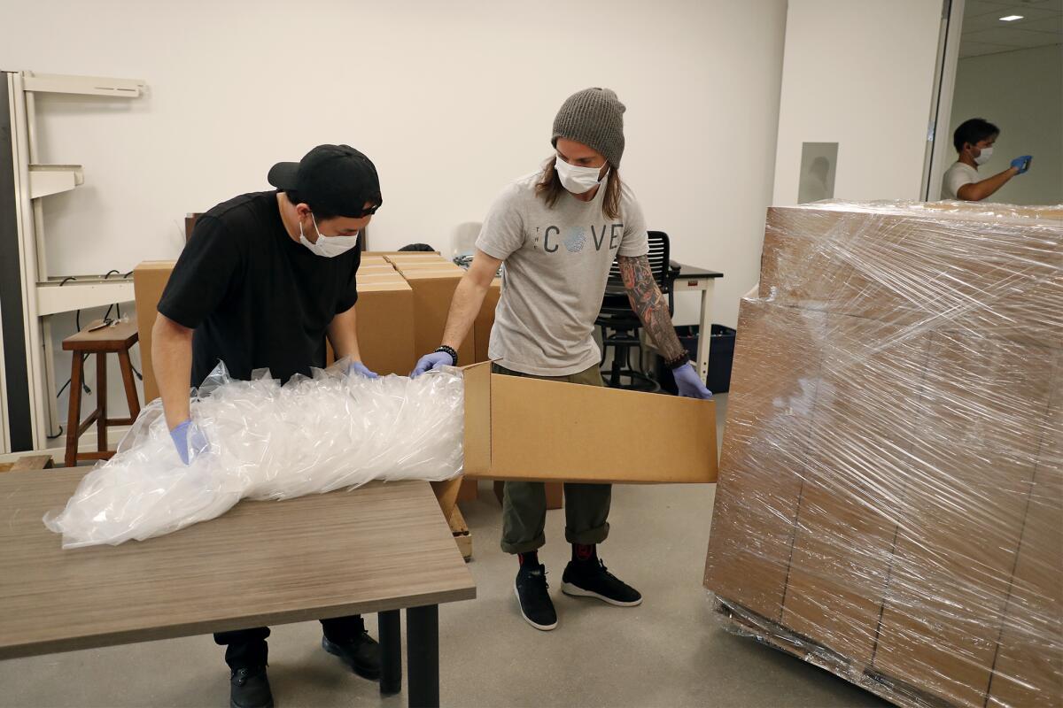 UC Irvine medical students package face shields produced with 3-D printers and laser cutters at the UCI Beall Applied Innovation Cove in Irvine on Tuesday.