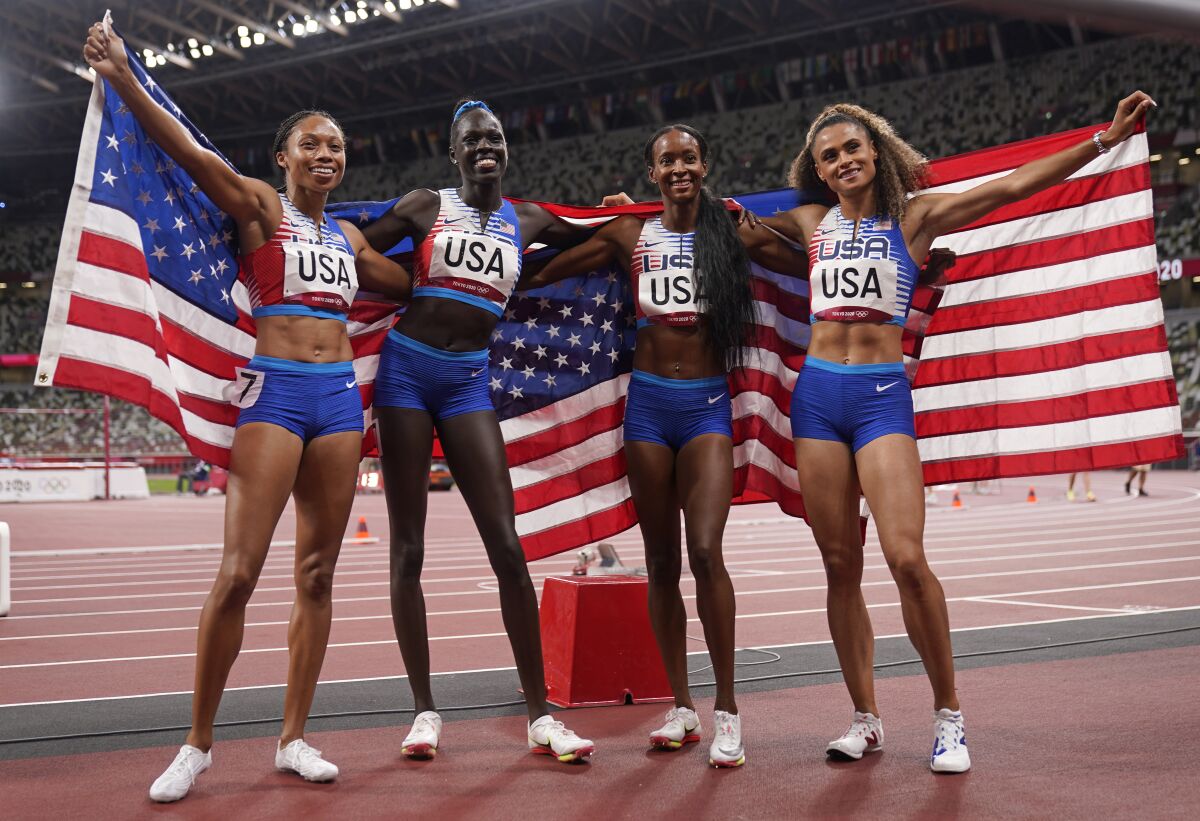 The United States team of Allyson Felix, Athing Mu, Dalilah Muhammad and Sydney Mclaughlin, from left, celebrate winning the gold medal in the final of the women's 4 x 400-meter relay at the 2020 Summer Olympics, Saturday, Aug. 7, 2021, in Tokyo, Japan. (AP Photo/Charlie Riedel)