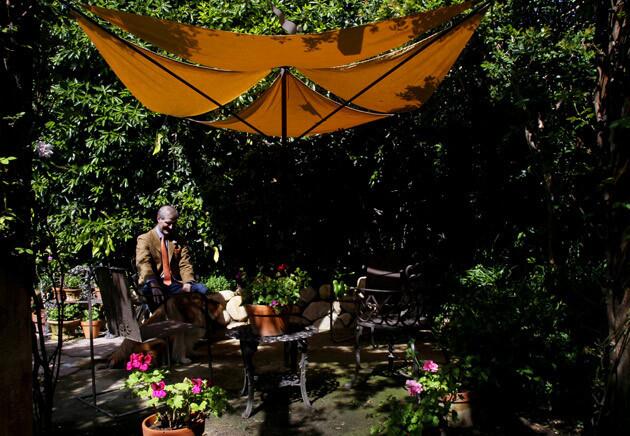 An artful umbrella with folding wrought-iron arms designed by local artist David Shelton, near the back of the garden, offers a shady spot for Becker and his associates to make a private call, have lunch or just take in the garden.