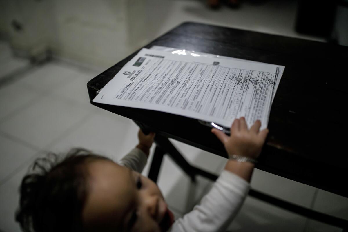 Jose Luis Zambrano Nunez, 9 months old, reaches for his Colombian birth certificate that states "not valid for citizenship." He was born in Colombia to Venezuelan parents.