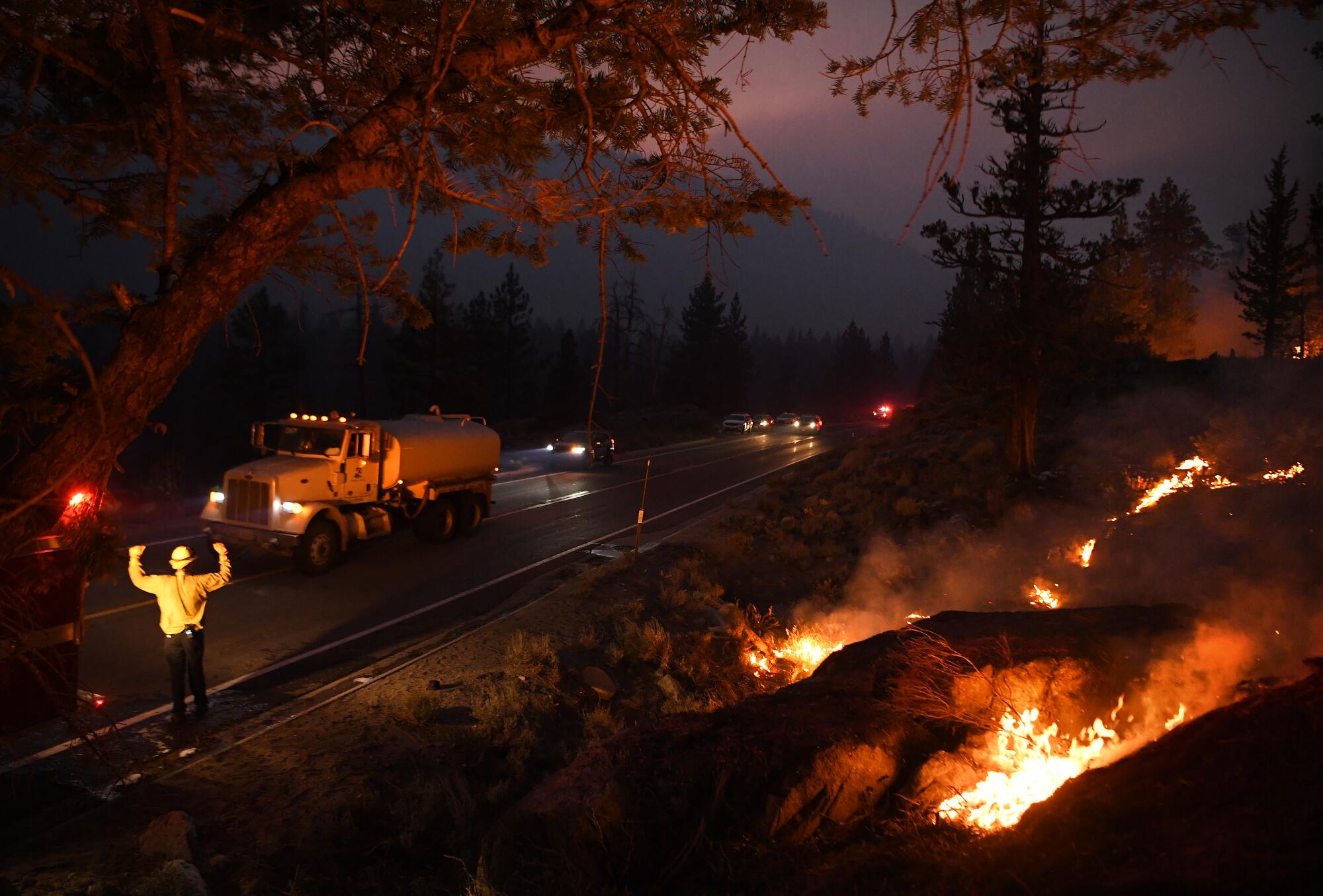 An Olympic Valley firefighter stops a truck for more water as the Caldor fire rages