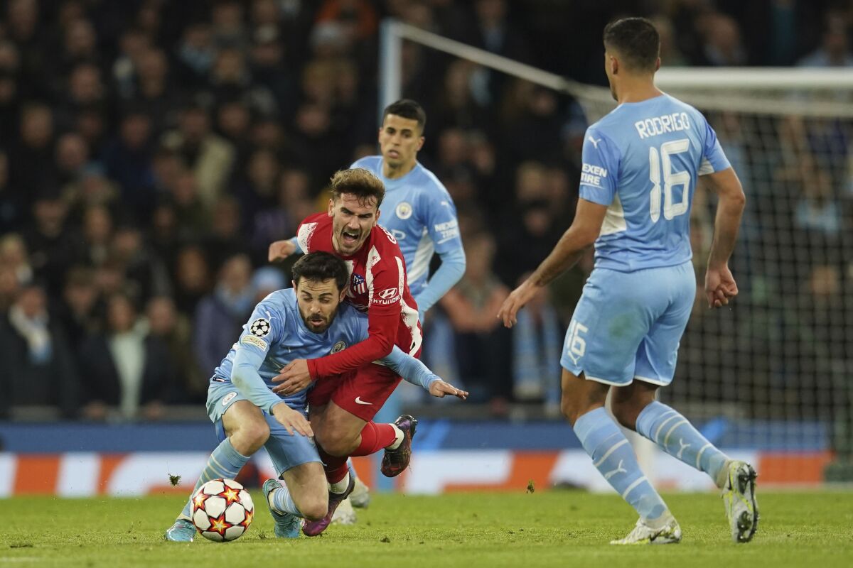 Manchester City's Bernardo Silva, left, fights for the ball with Atletico Madrid's Antoine Griezmann during the Champions League, first leg, quarterfinal soccer match between Manchester City and Atletico Madrid at the Etihad Stadium, in Manchester, Tuesday, April 5, 2022. (AP Photo/Dave Thompson)
