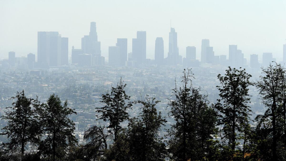 Air quality has slipped in recent years, and regulators are falling far short of raising billions they say is needed to clean ozone pollution in time to avoid tough economic sanctions. Here, smog hangs over downtown Los Angeles in 2018.