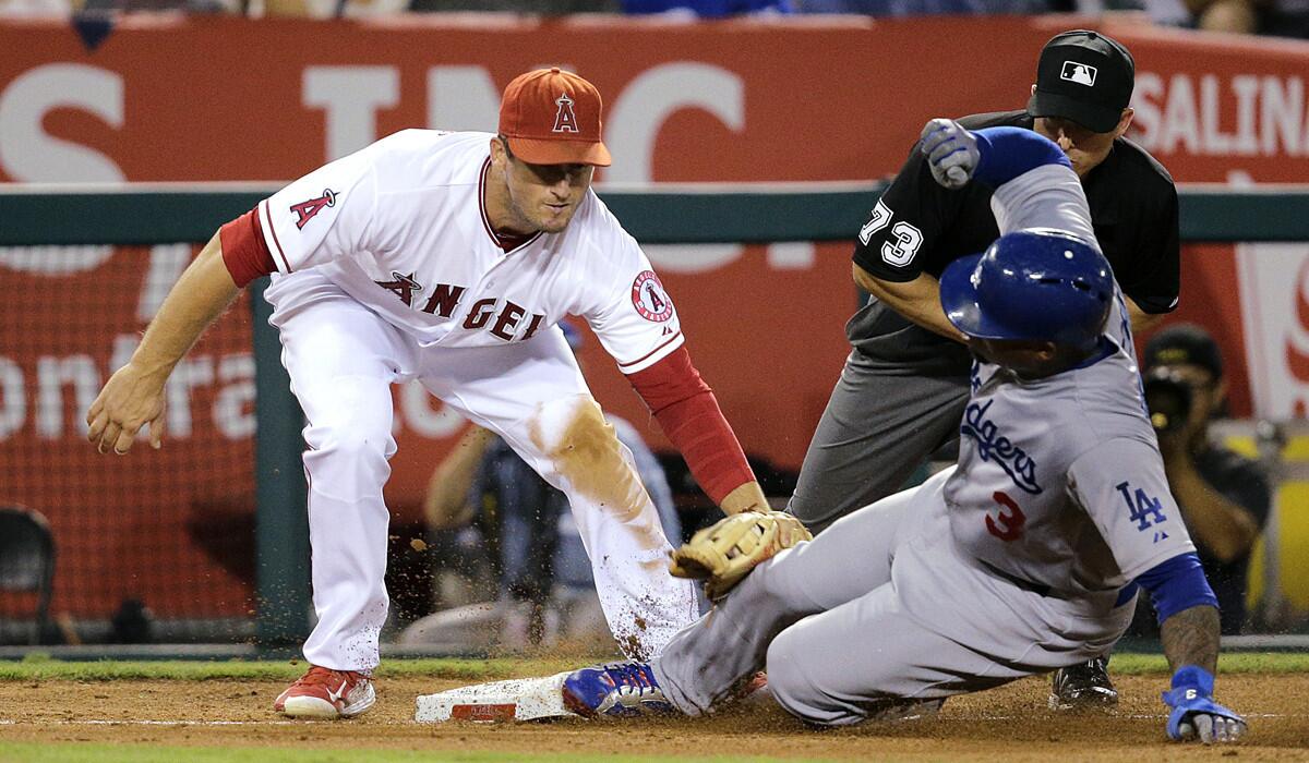 Dodgers' Carl Crawford, right, steals third base against Angels third baseman David Freese during the sixth inning on Tuesday.