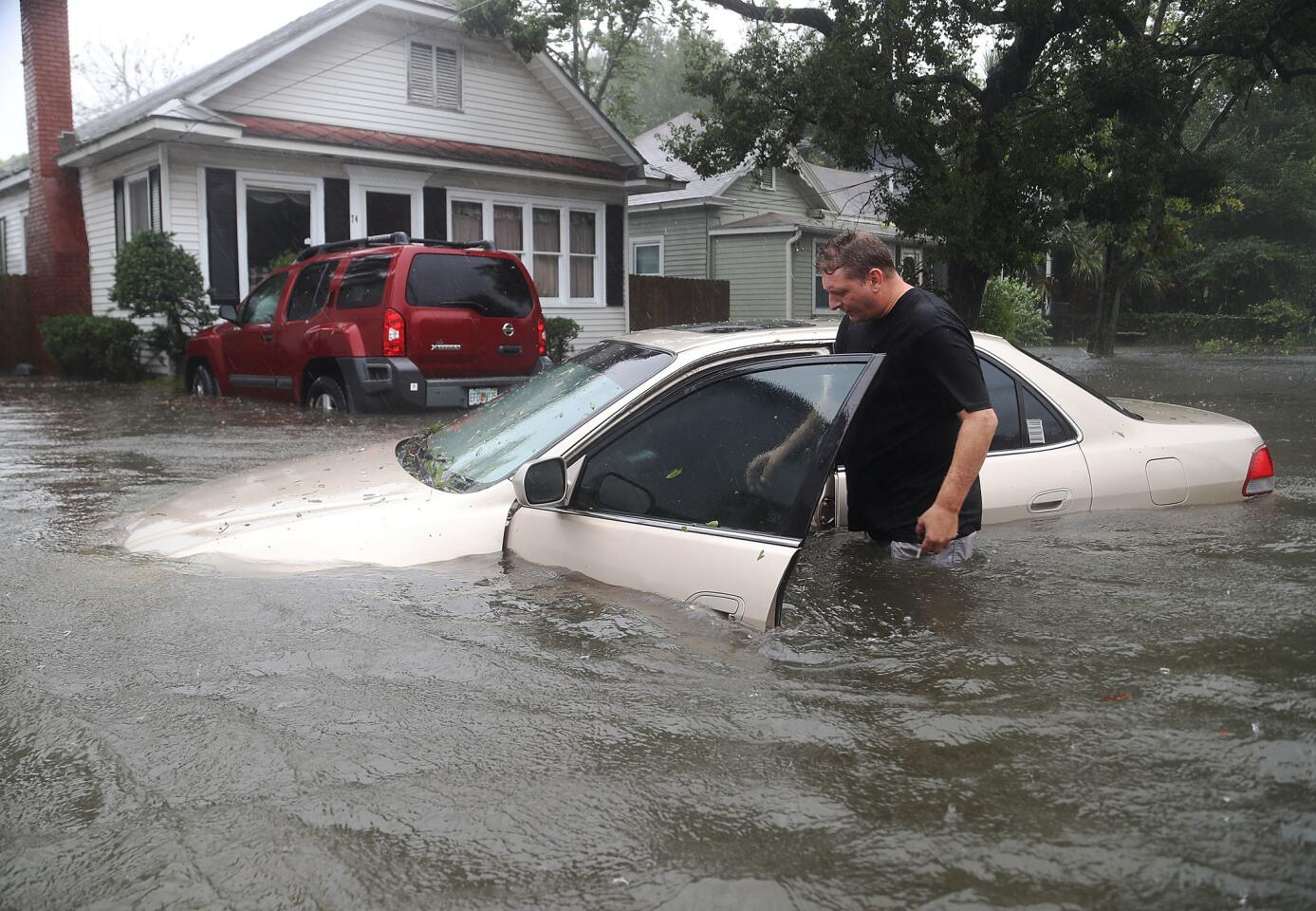 Rob Birch checks on his car floating out of the driveway as Hurricane Matthew passes through St. Augustine, Fla.