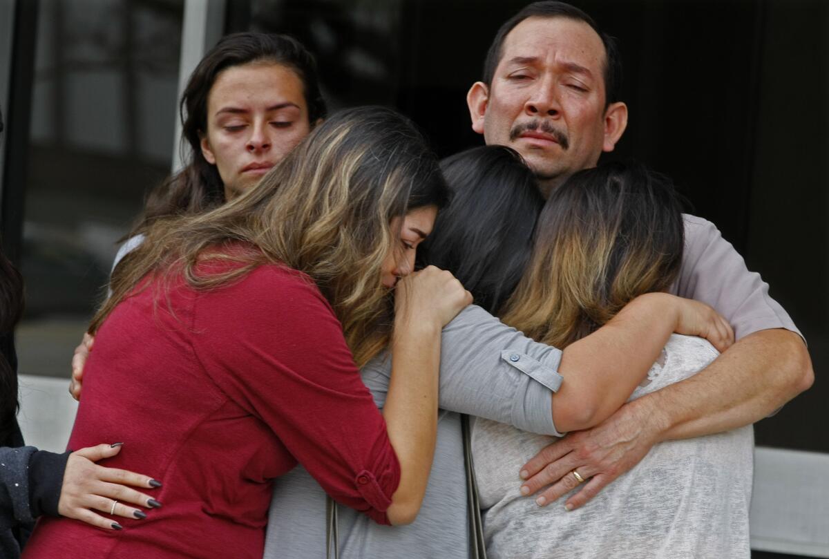 Family members of Erica Alonso, a woman who has been missing for a week, hug during a press conference at the Orange County sheriff's headquarters.