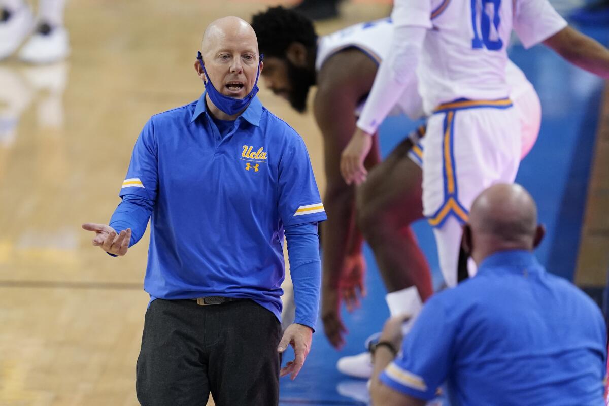UCLA coach Mick Cronin speaks while standing on the sideline during a game against Marquette.