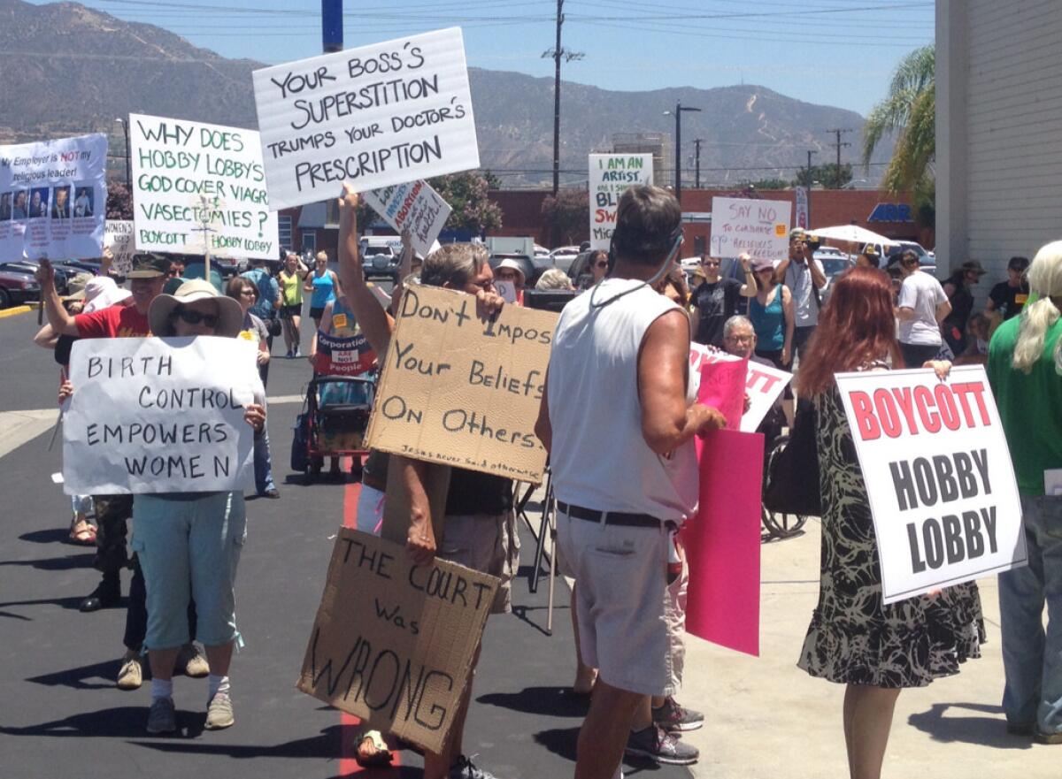 Protesters at Hobby Lobby in Burbank march in protest of a recent U.S. Supreme Court decision at the store's grand opening.